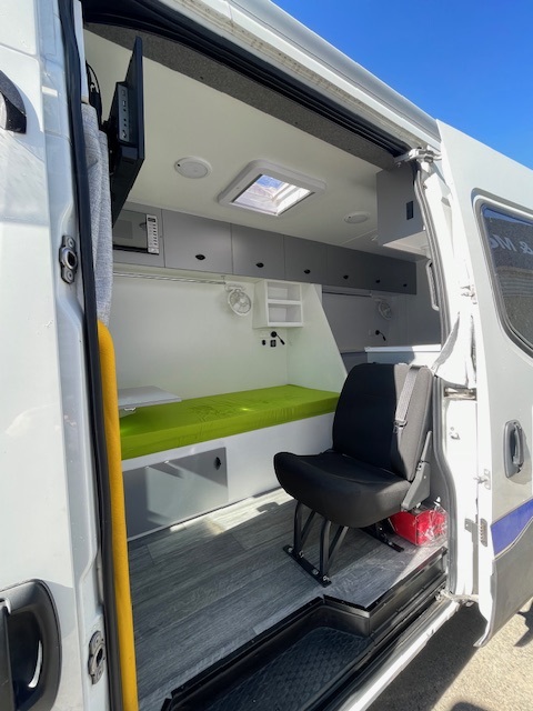 Fitted campervan kitchen with fridge, microwave and cabinetry by Focus RV