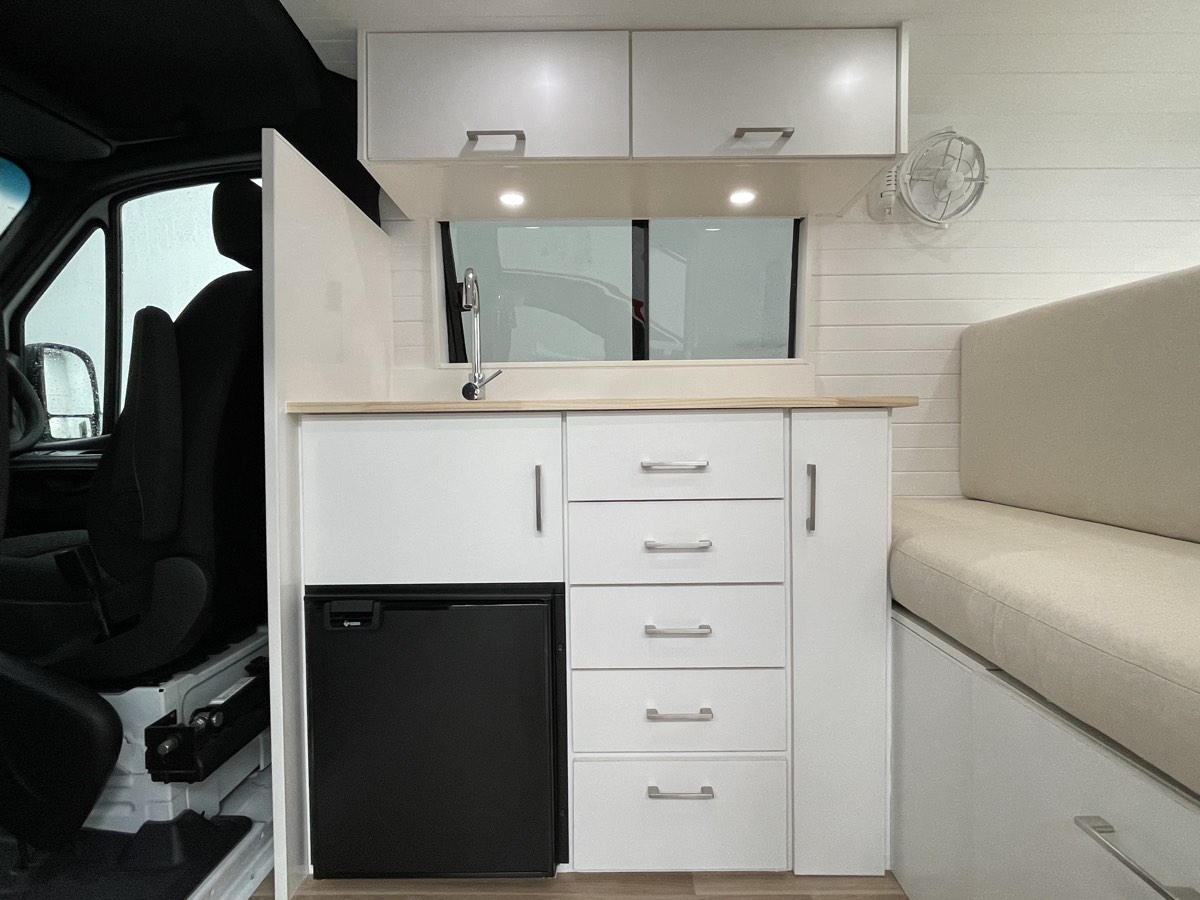 Compact Sprinter kitchen with fridge, sink and seating by Focus RV